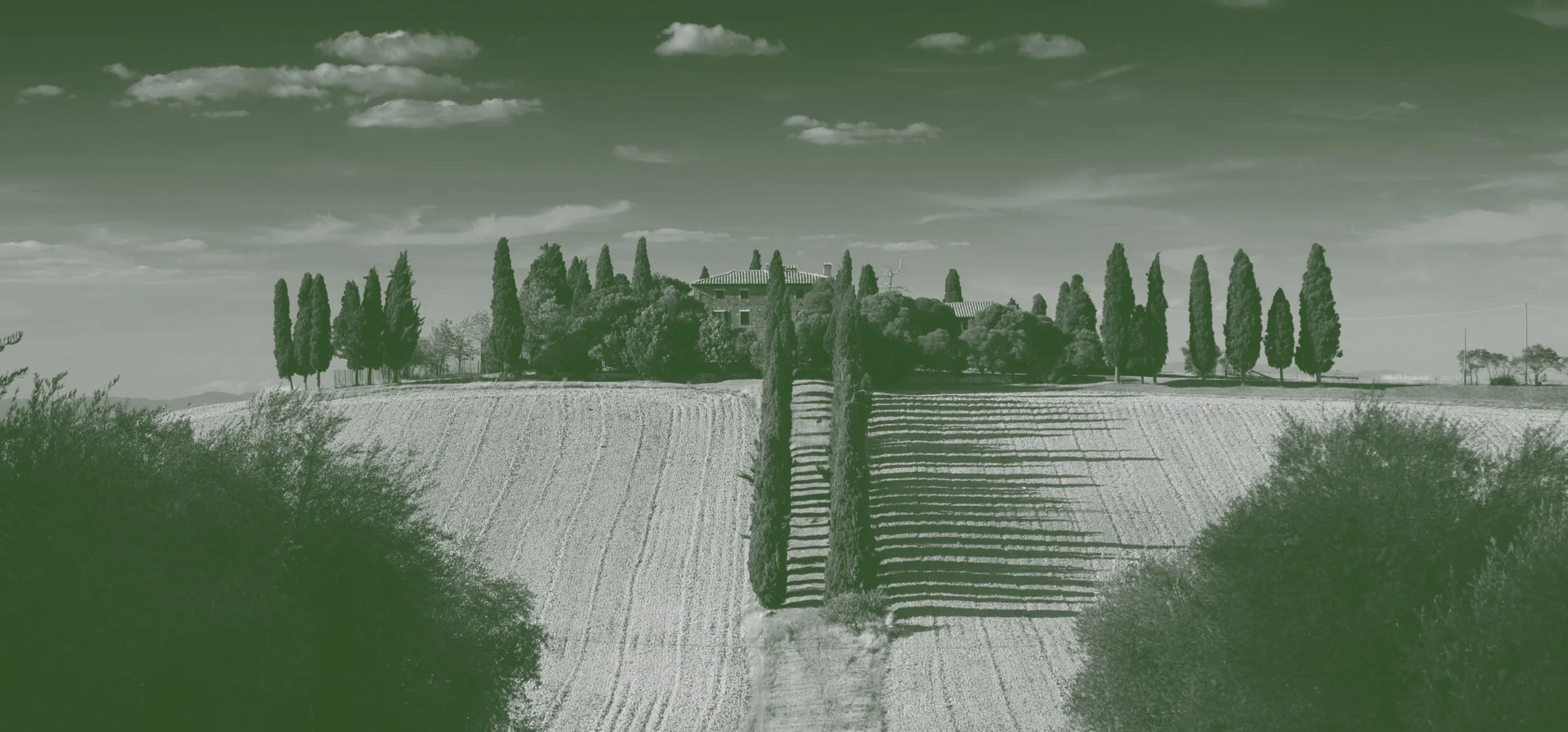Paisatge toscà clàssic amb masia entre cipresos i camps ondulats